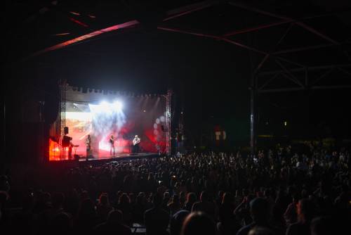 Koncert Szczyla. Publiczność pod sceną bawi się podczas koncertu. Daleki kadr na scenę.