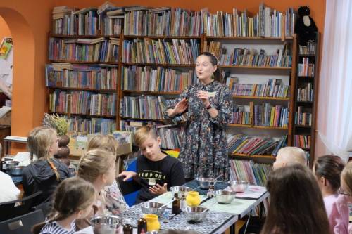 Prowadząca warsztaty pokazuje dzieciom, jak pracować nad zadaniem.