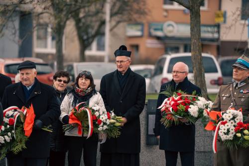 Goście stojący przed tłumem z kwiatami.