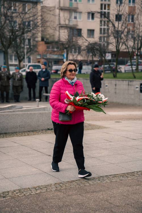 E. Urbanowicz składa kwiaty pod pomnikiem Nike.