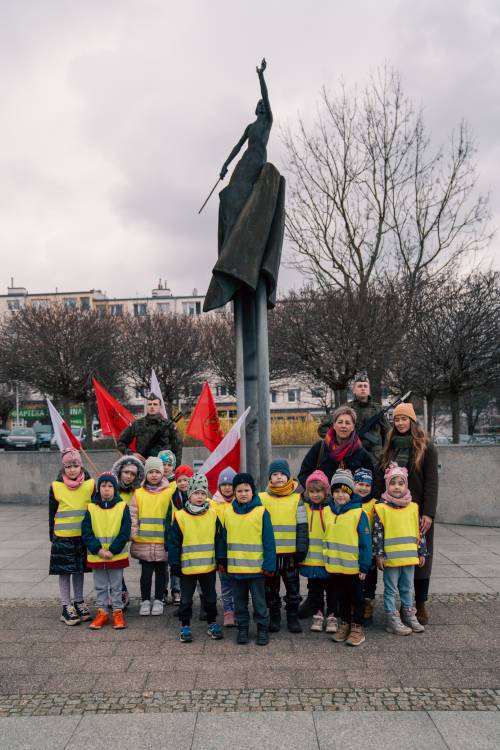 Przedszkolaki z opiekunkami pod pomnikiem Nike.