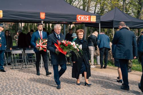 Oficjele składają kwiaty podczas obchodów upamiętniających zbrodnię katyńską w obstawie żołnierzy.