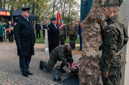 Mundurowi składają kwiaty podczas obchodów upamiętniających zbrodnię katyńską w obstawie żołnierzy.