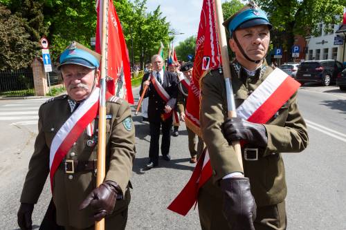 Zbliżenie na żołnierzy AK ze sztandarami.