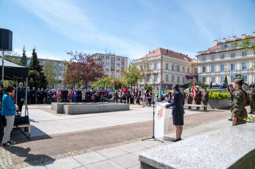 Szeroki kadr. Przy mównicy przedstawicielka policji. W tle budynek Starostwa Powiatowego i goście.