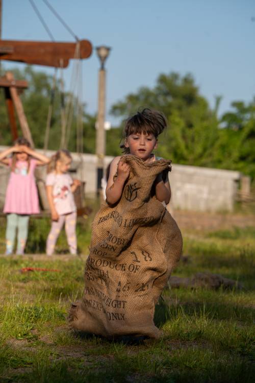 Skacząca dziewczynka w jutowym worze.