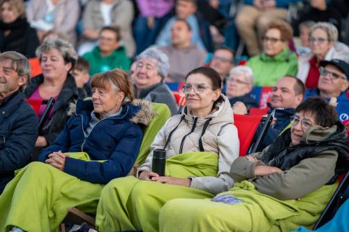 Zbliżenie na publiczność. Kobiety w zawinięte w zielone koce.