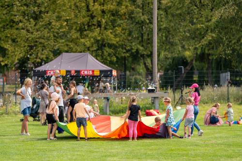 Zabawa podczas festynu na boisku przy Centrum Kultury i Sportu w ramach cyklu Wakacje w Mieście. Na zdjęciu zabawa kolorową chustą.