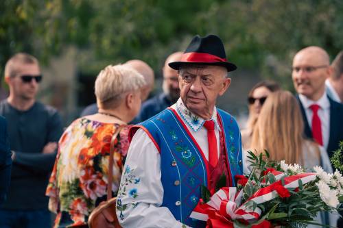 Goście z kwiatami podczas przemarszu.