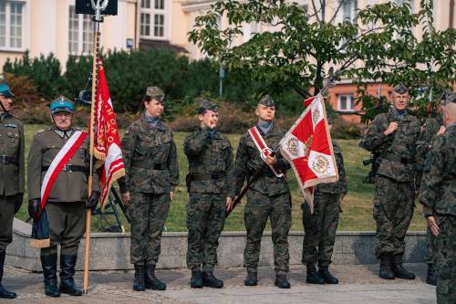 Żołnierze ze sztandarami podczas przemarszu.