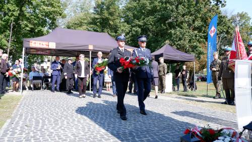 Składanie kwiatów pod pomnikiem przez gości.