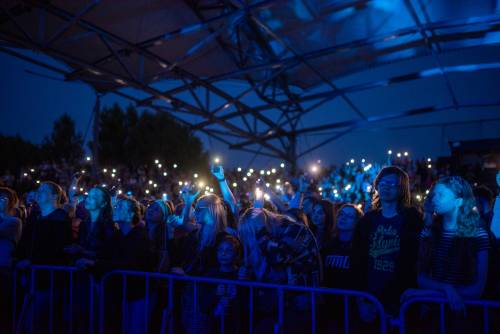 Publiczność trzyma zapalone latarki w komórkach