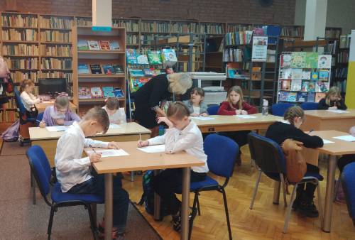 Uczniowie podczas pisania testu w bibliotece.