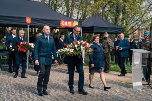 Burmistrz Pruszcza Gdańskiego, Przewodnicząca Rady Miasta i Zastępca Burmistrza ds. komunalnych składają kwiaty podczas obchodów upamiętniających zbrodnię katyńską w obstawie żołnierzy.