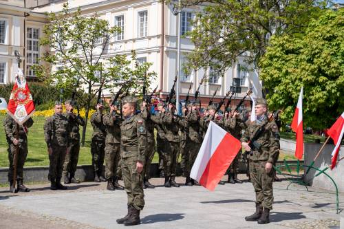 Żołnierze z flagą państwową na placu Jana Pawła II. W tle budynek Starostwa Powiatowego.