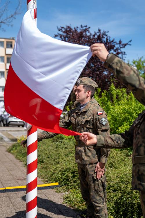 Żołnierze wciągają flagę Państwową na maszt.