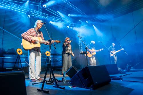 Czterech muzyków na scenie. Widok z boku.