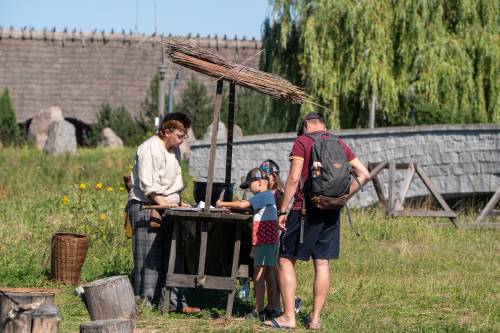 Na zdjęciu uczestnicy Weekendu Piśmiennictwa na Faktorii Handlowej przy jednym ze stoisk wraz z animatorem w stroju z dawnej epoki.