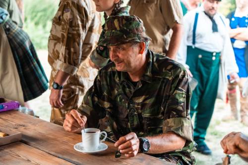 Zdjęcie przedstawia aktywności podczas Drop Zone w Faktorii Handlowej. rekonstruktorzy oraz uczestnicy siedzą przy stole.