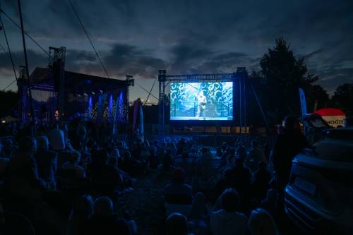 Zdjęcie sceny i publiczności z oddalenia podczas Wieczoru Stand-Up w ramach cyklu Faktoria Kultury w Pruszczu Gdańskim.