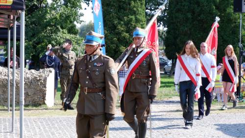 Składanie kwiatów pod pomnikiem przez gości.