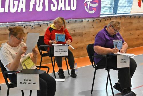 Trzy kobiety siedzą przy stolikach i rozwiązuje test.