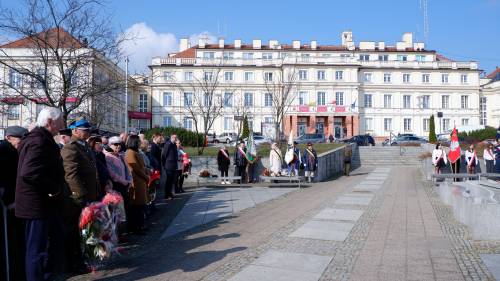 Uczestnicy obchodów zebrani na Placu Jana Pawła II w Pruszczu Gdańskim. W tle budynek Starostwa Powiatowego.
