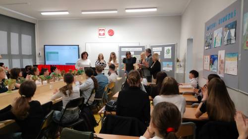 Uczniowie- uczestnicy odbierają dyplomy. Widok z tyłu sali.
