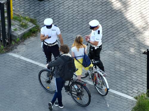 Dwoje rowerzystów w towarzystwie policjantów