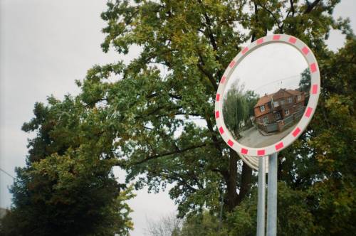 Lustro uliczne, w którym odbija się stary budynek.