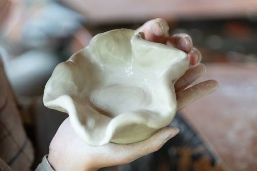 Na zdjęciu naczynie ceramiczne w rękach uczestnika warsztatów