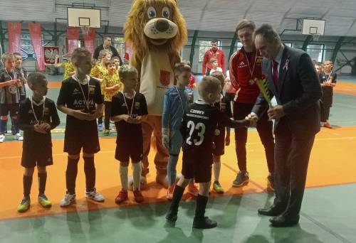 Na zdjęciu stoi obok siebie grupa osób, nagrodzonych za udział w turnieju piłki nożnej