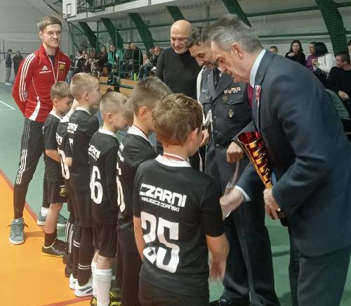 Na zdjęciu stoi obok siebie grupa osób, nagrodzonych za udział w turnieju piłki nożnej