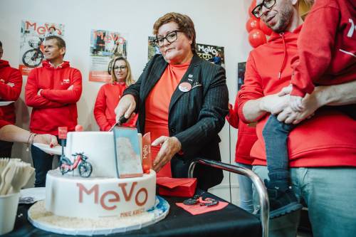 Uroczystość, czerwone stroje, kobieta kroi tort.