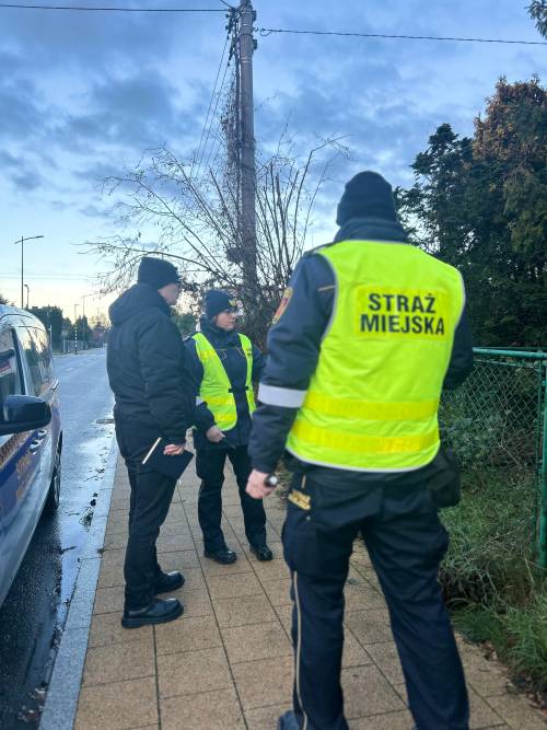 Trzy postacie stojące na chodniku