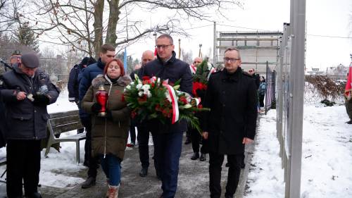 Burmistrz, z innymi osobami trzymający wieniec