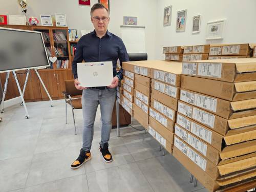 Mężczyzna trzyma nowy laptop marki HP.