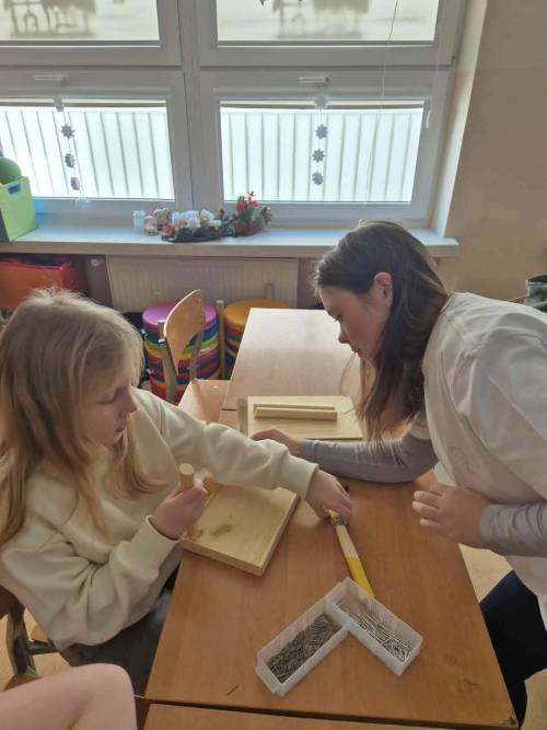 Uczennice budują karmnik podczas zajęć