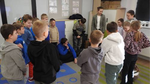 Dzieci i pani stoją w kole i rozmawiają