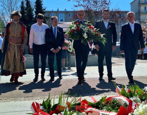 Grupa radnych idzie z burmistrzem Pruszcza złożyć wiązankę kwiatów