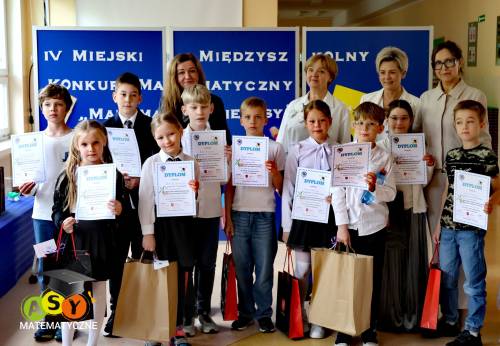Grupa dzieci z dyplomami i nagrodami wraz nauczycielkami i dyrektor szkoły
