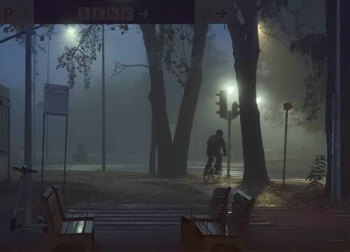 Ulica z chodnikiem, ławkami i rowerzystą nocą