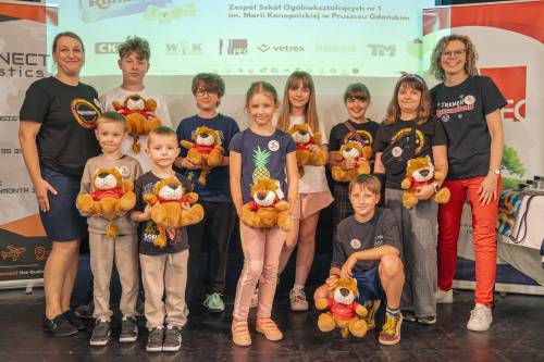 Grupa dzieci trzyma w rękach maskotki lwy