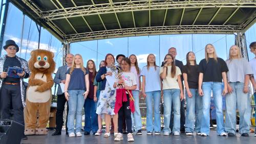 Grupa młodzieży z dorosłymi na scenie