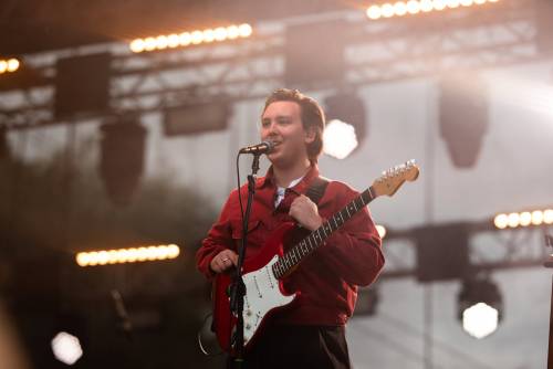 Mężczyzna piosenkarz z gitarą stoi na scenie