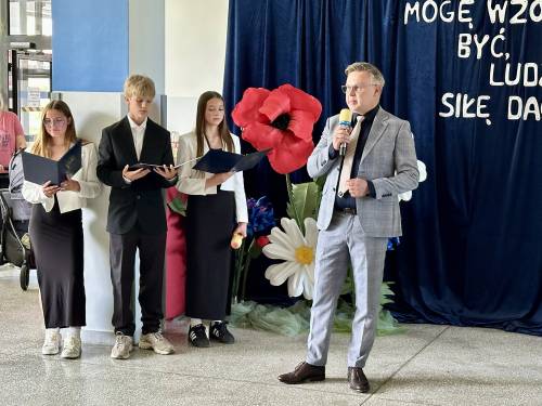 Trójka uczniów i dyrektor szkoły z mikrofonem