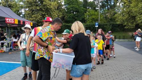 Kobieta i mężczyzna trzymają w rękach pudełko, z którego dziecko coś wyciąga
