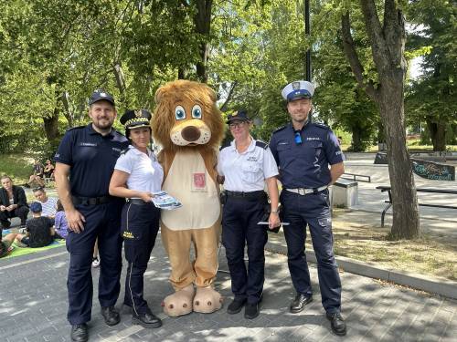 Funkcjonariusze policji i straży miejskiej z maskotką lwem