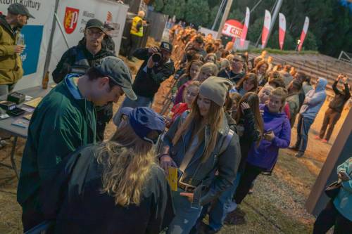 Młodzi ludzie stoją w kolejce po autograf muzyka