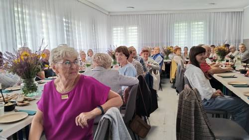 Widok na salę z siedzącymi seniorami